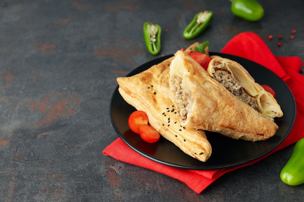 Concept of tasty food with samsa on dark textured background